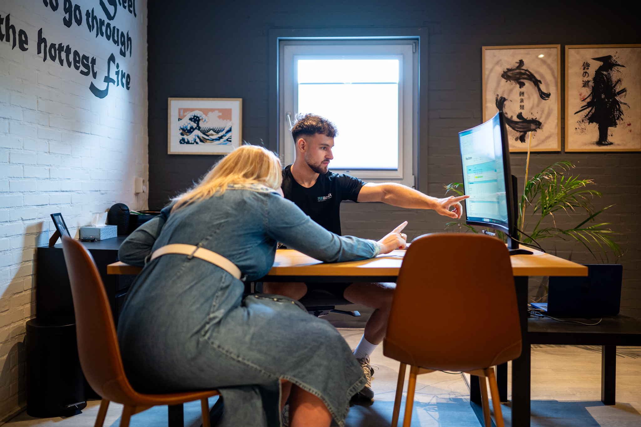 Foto waar trainer Jeroen samen met klant naar voedingsapp aan het kijken zijn