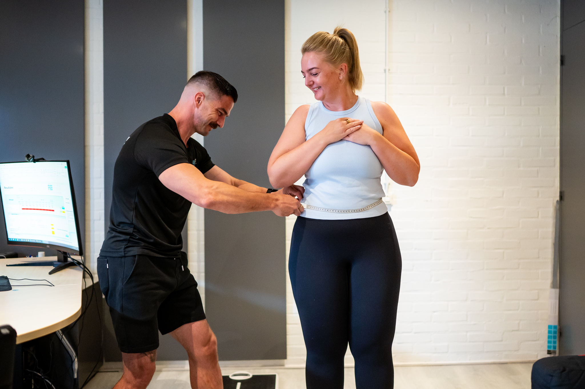 Foto van Rebody Coach Ben die buikomtrek aan het meten is bij klant