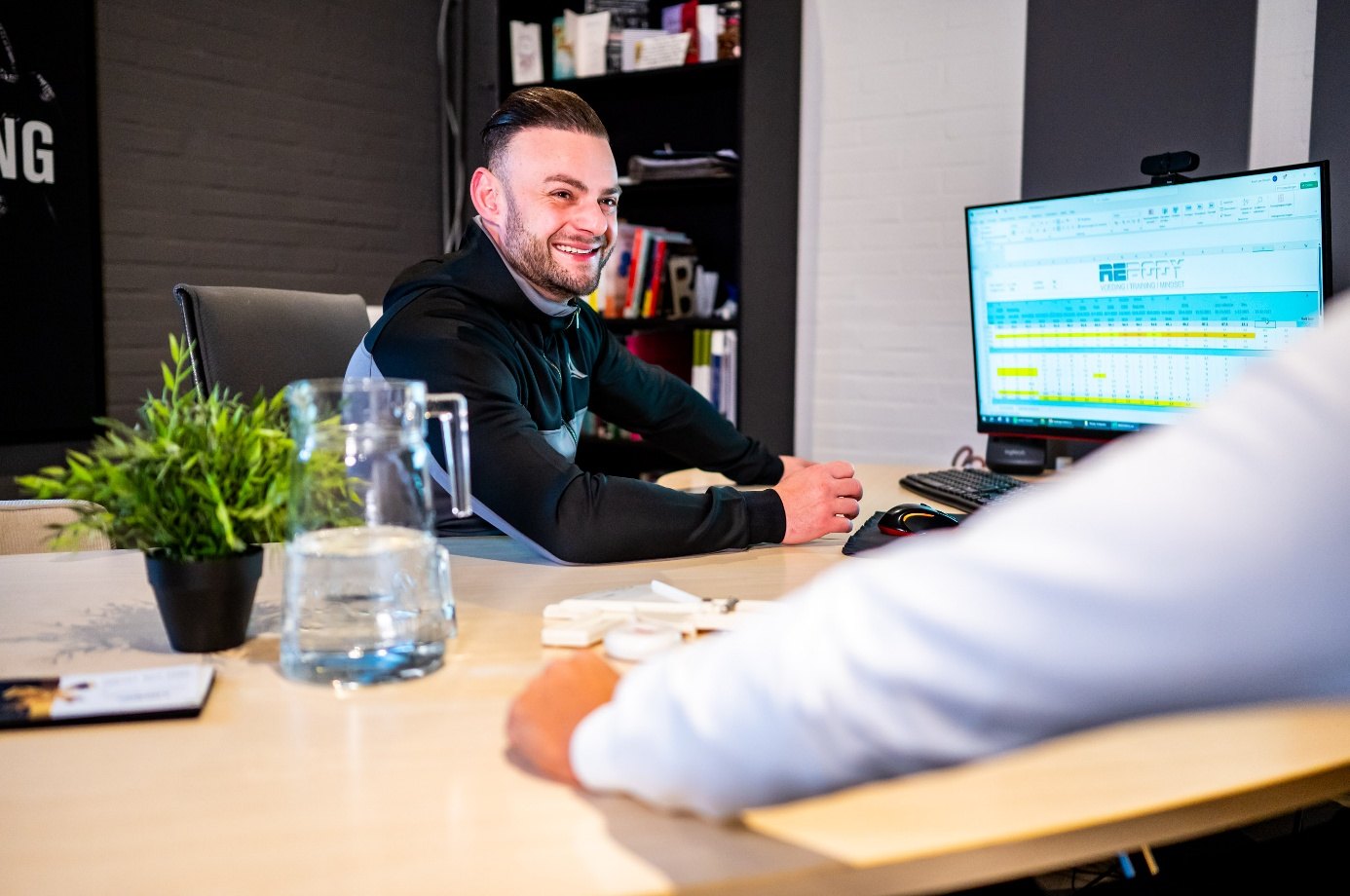 Coach in gesprek met een klant aan het bureau tijdens een coachsessie