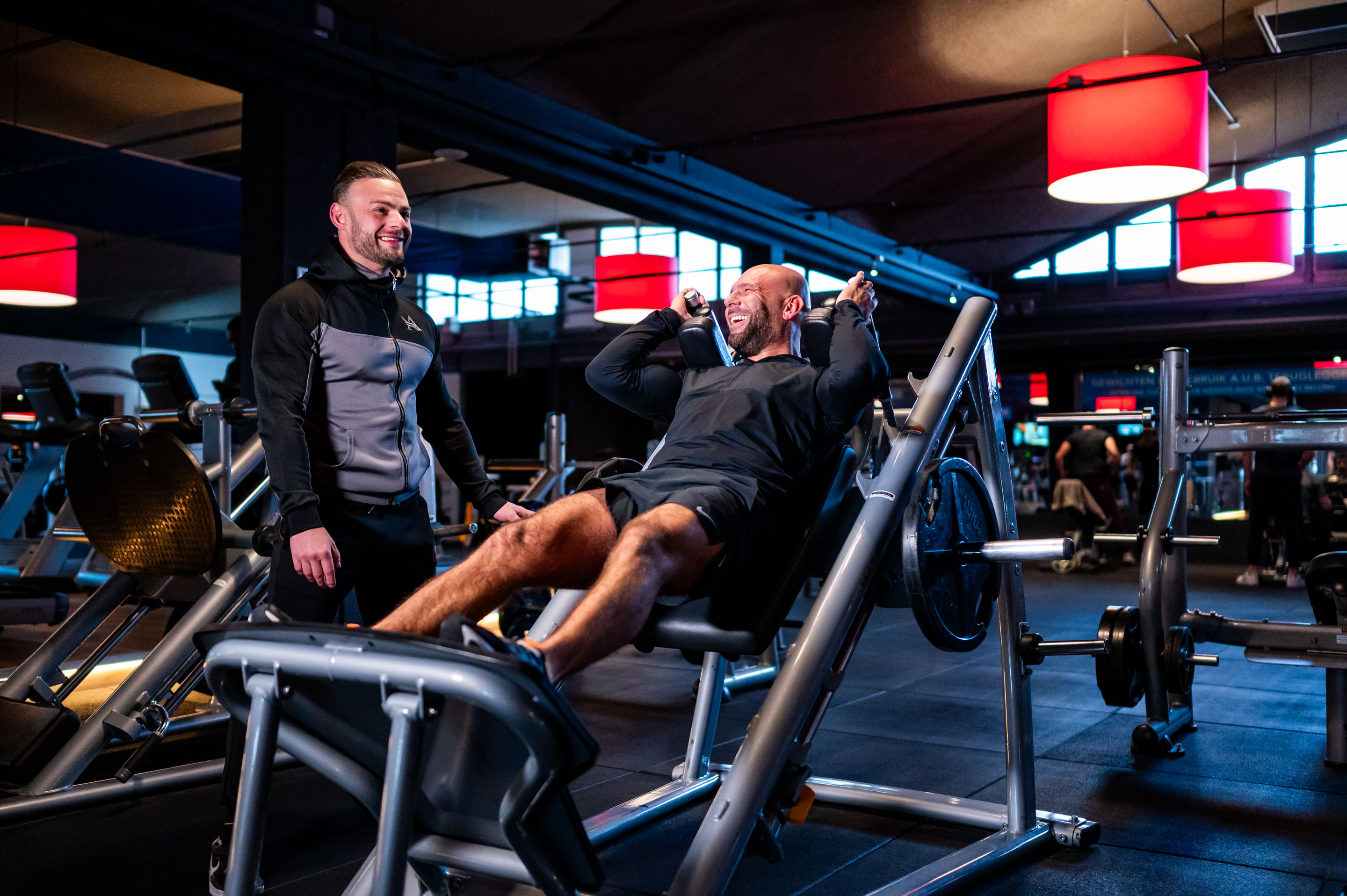 Coach Kevin is iemand aan het begeleiden met krachttraining